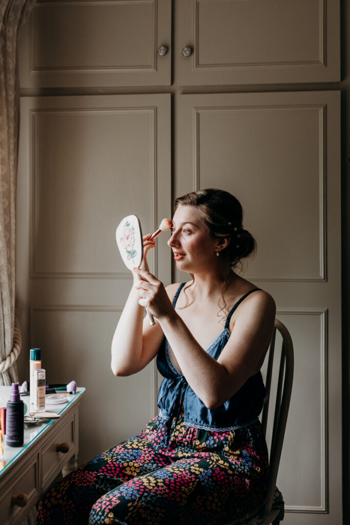 Bride putting make up on at The Normans York