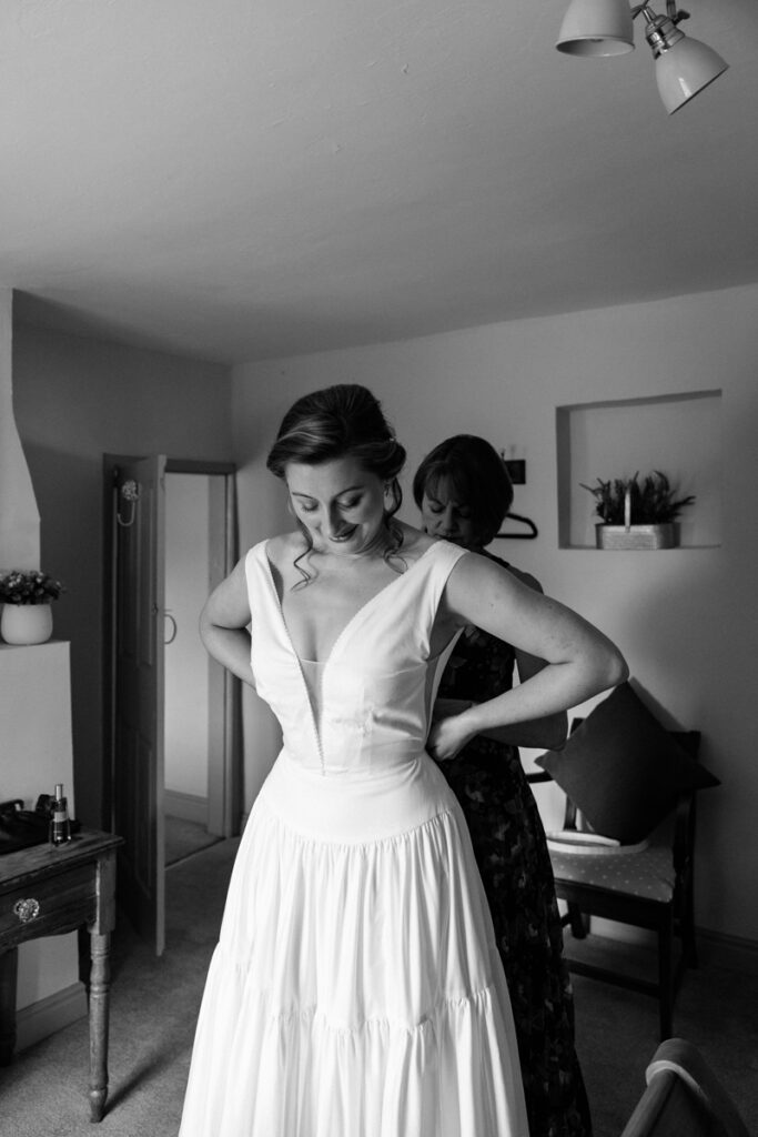 Mum getting bride into dress at The Normans York