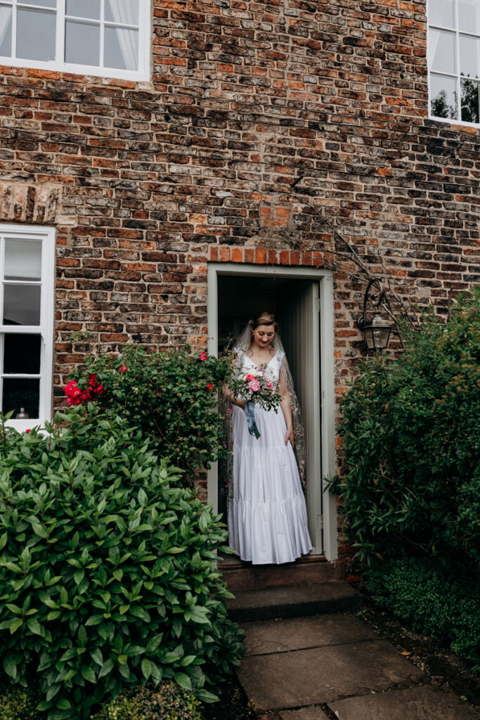 Bride coming out of cottage at The Normans York