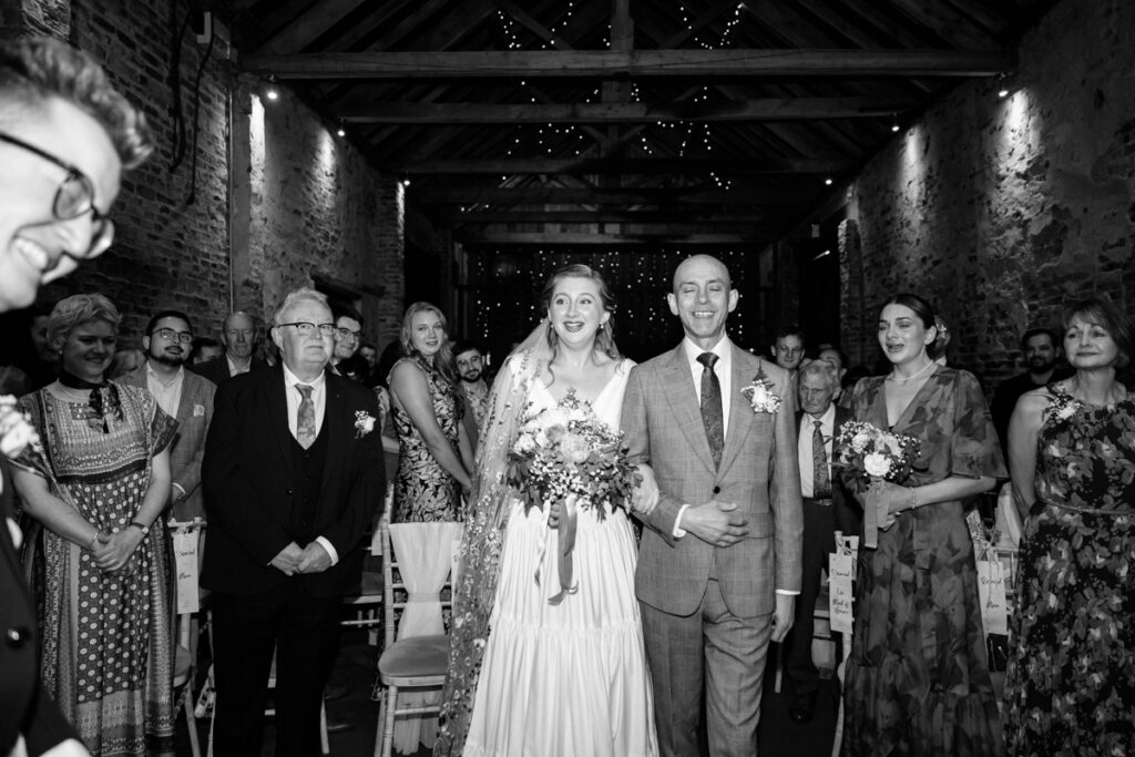 Bride walking down the aisle in black and white at The Normans York