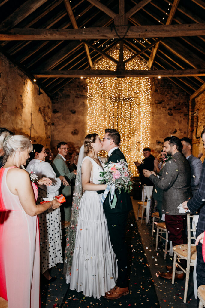 Bride and groom in confetti kissing