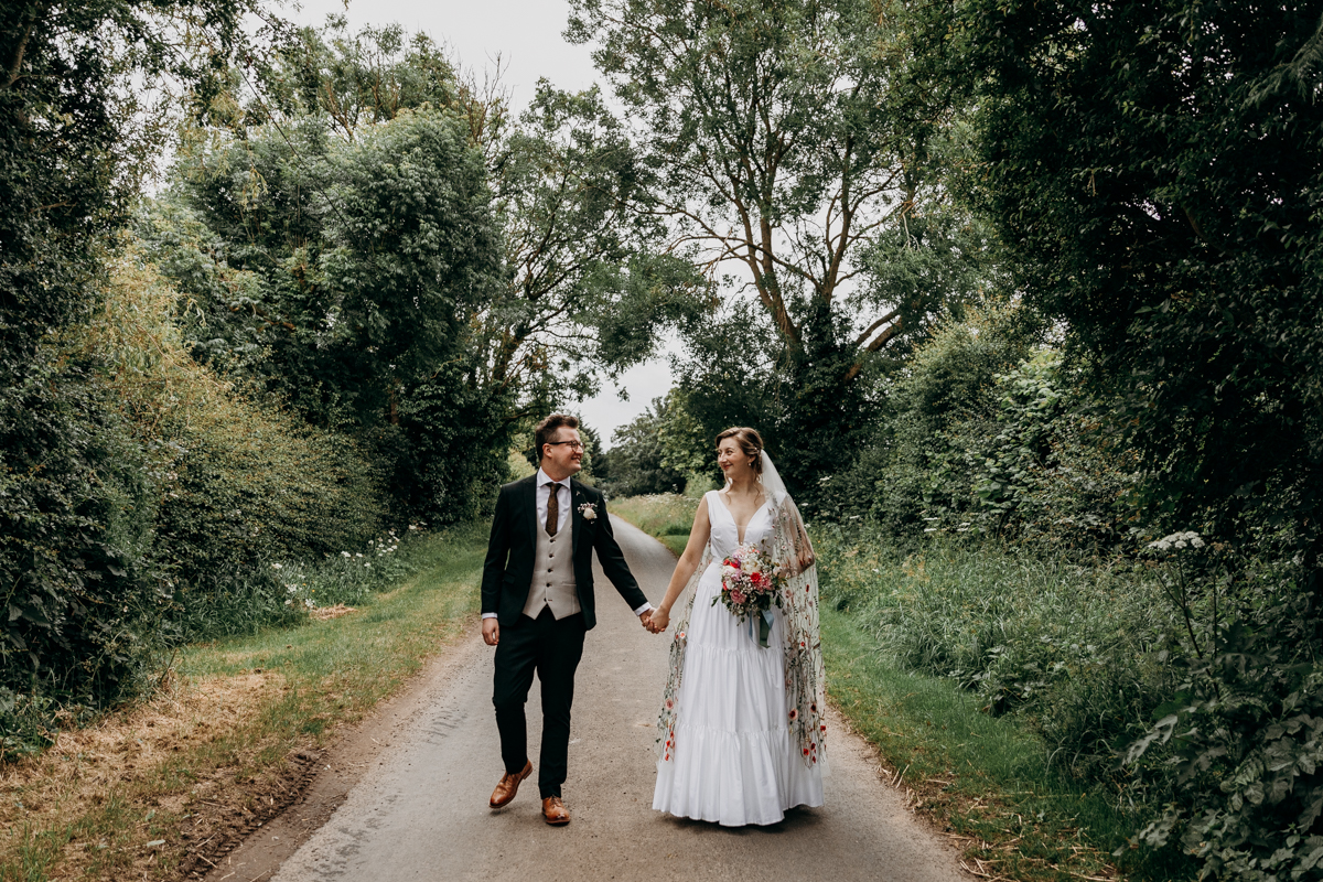 Bride and groom walking down country lane at The Normans York