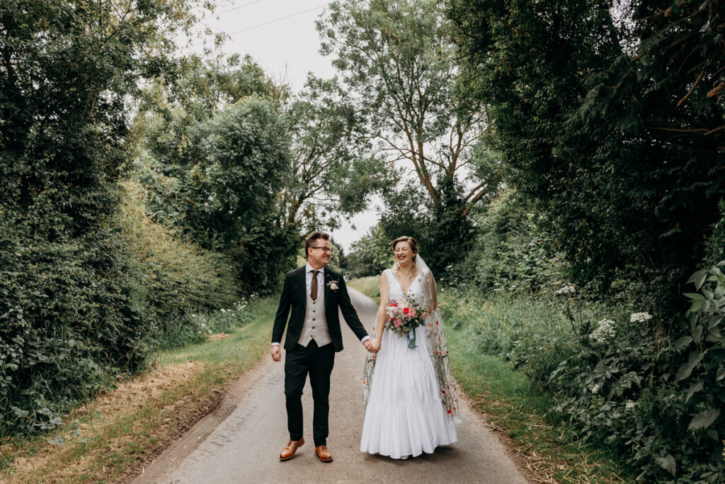 Bride and groom walking down country lane at The Normans York