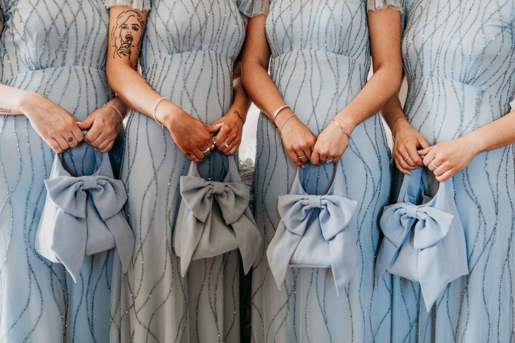 Bridesmaid holding bow bags at Thicket Priory