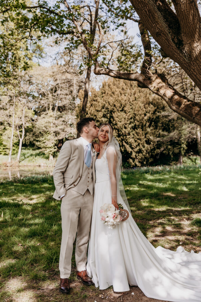 Groom kissing bride at Thicket Priory