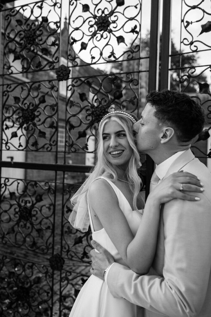 Groom kissing bride at Thicket Priory