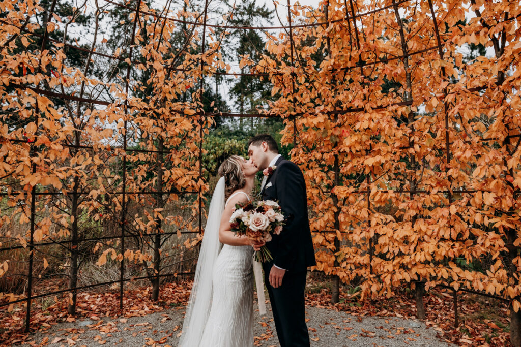 Bride and groom kissing in walled garden at Middleton Lodge
