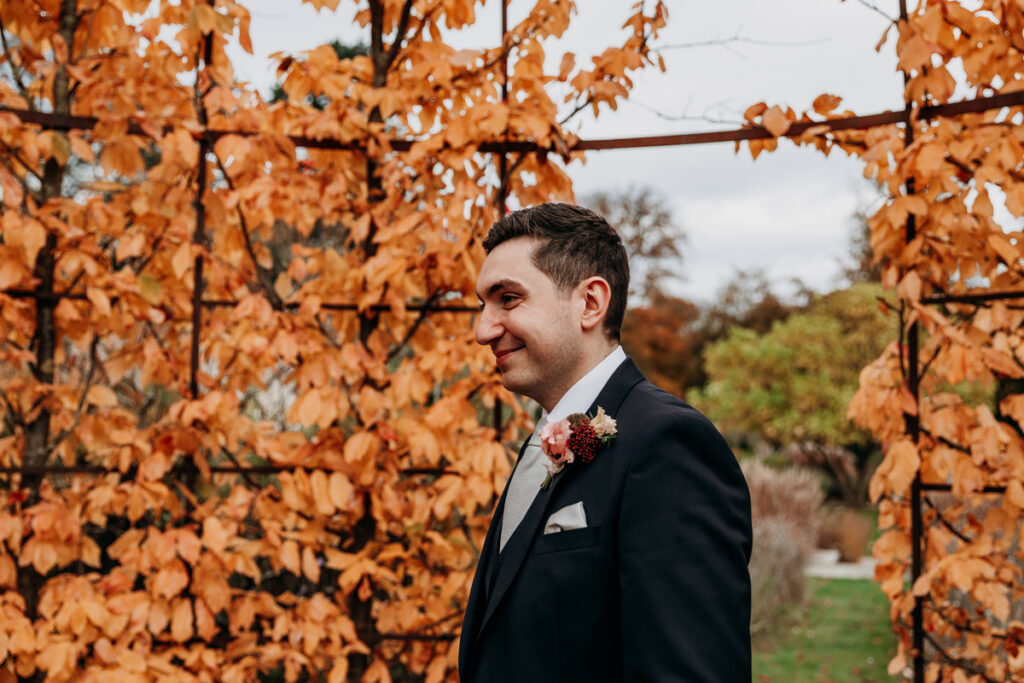 Groom smiling at bride in walled garden at Middleton Lodge