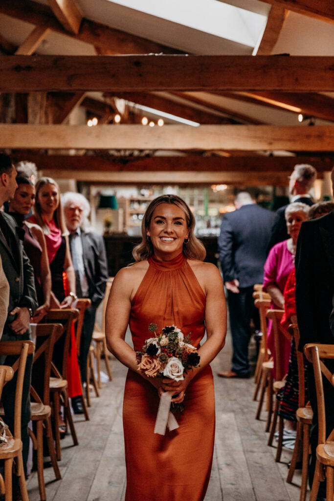Bridesmaid walking down aisle at Middleton Lodge