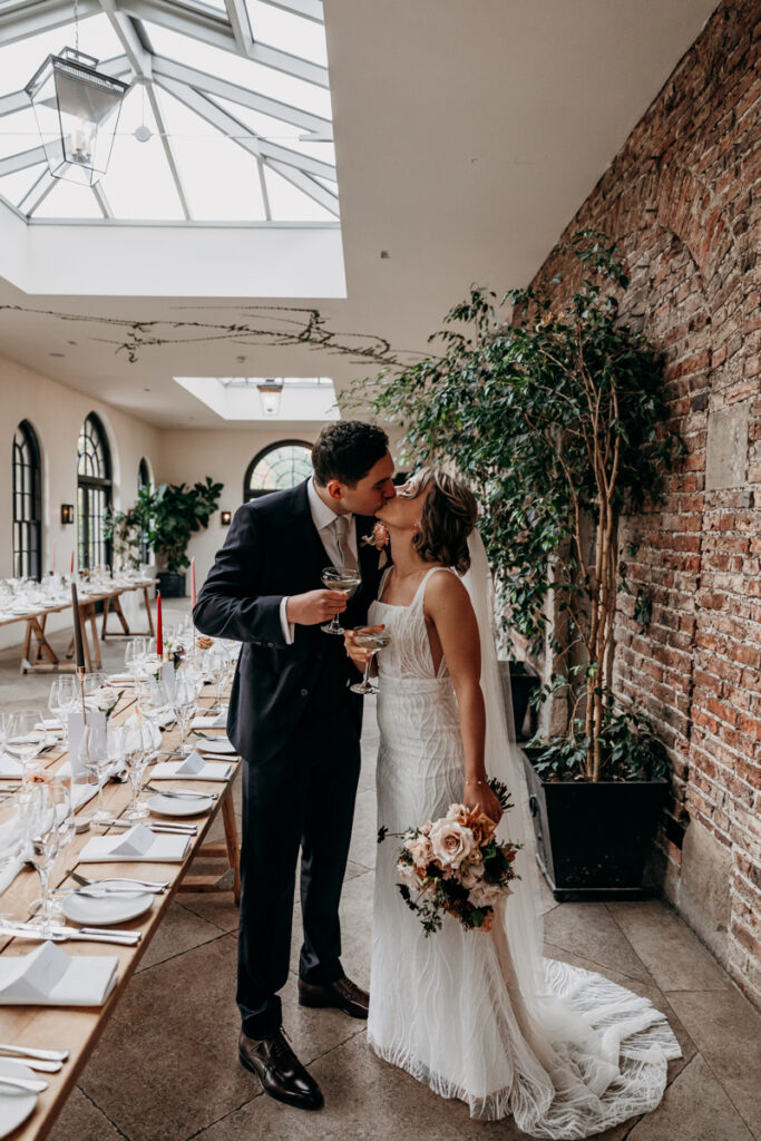 Bride and groom kissing in The Fig House at Middleton Lodge