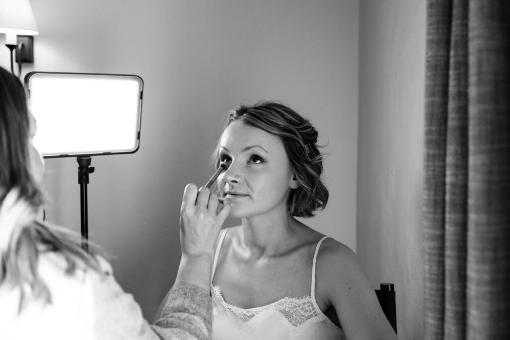 Bride having make up done in black and white