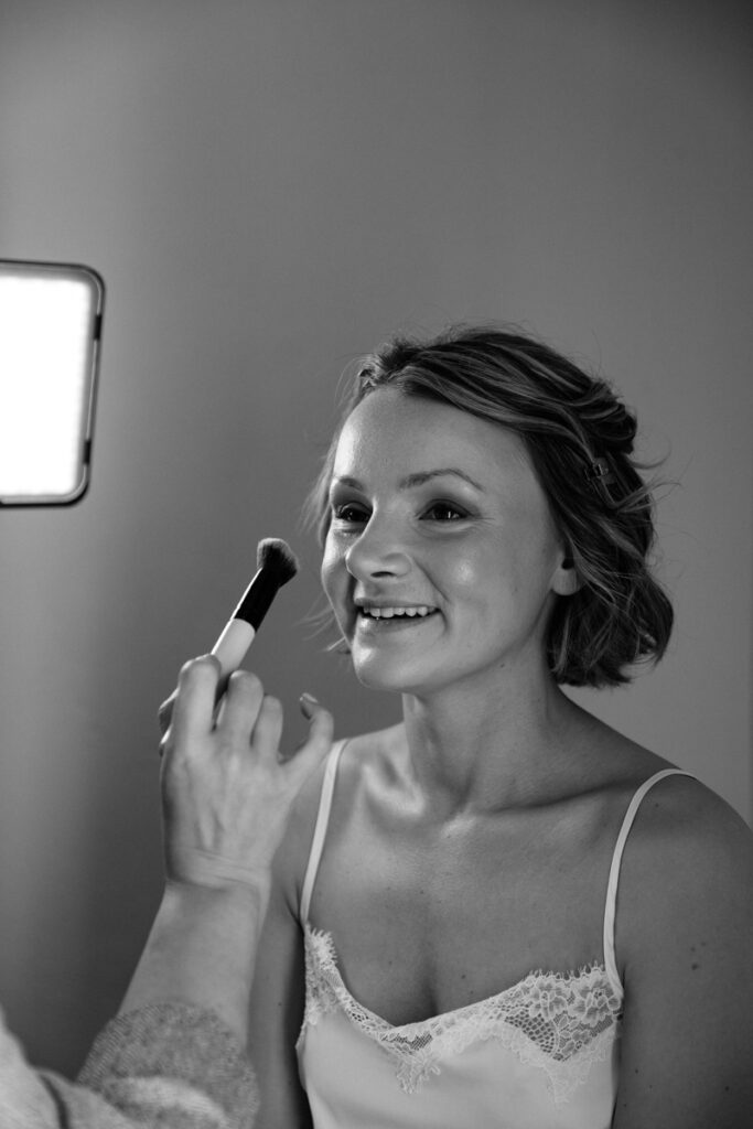 Bride having make up done in black and white