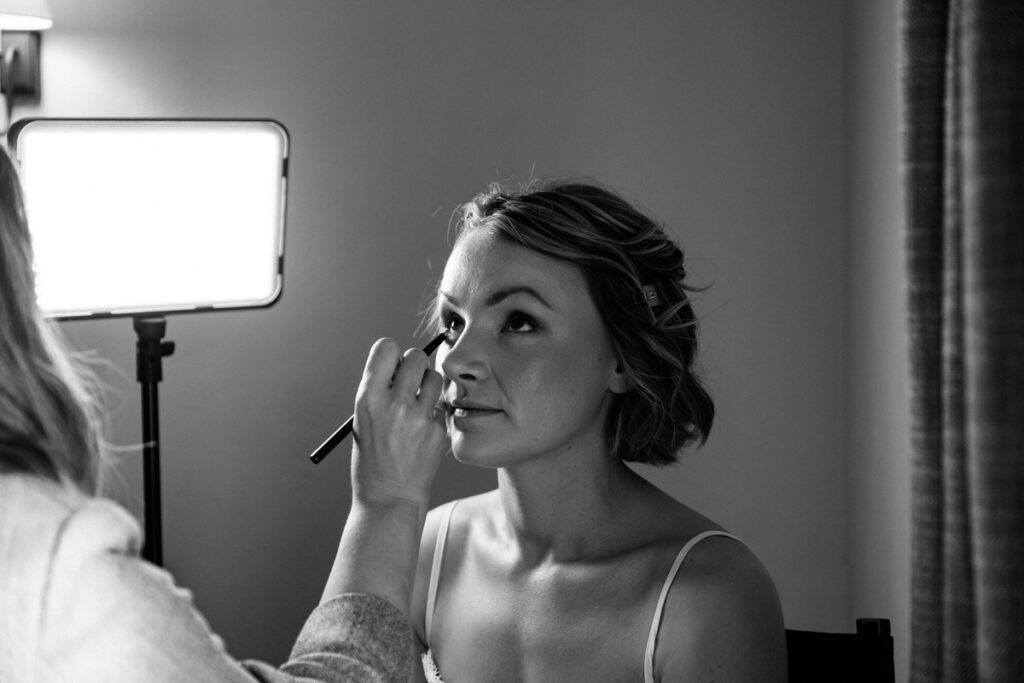 Bride having make up done in black and white