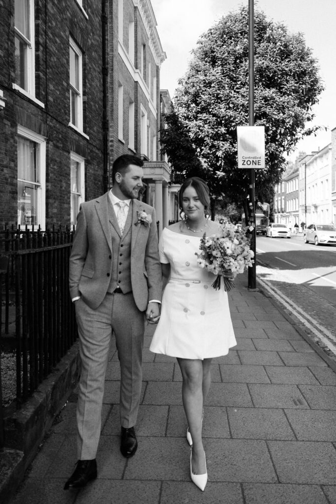 Bride and Groom walking through York in black and white