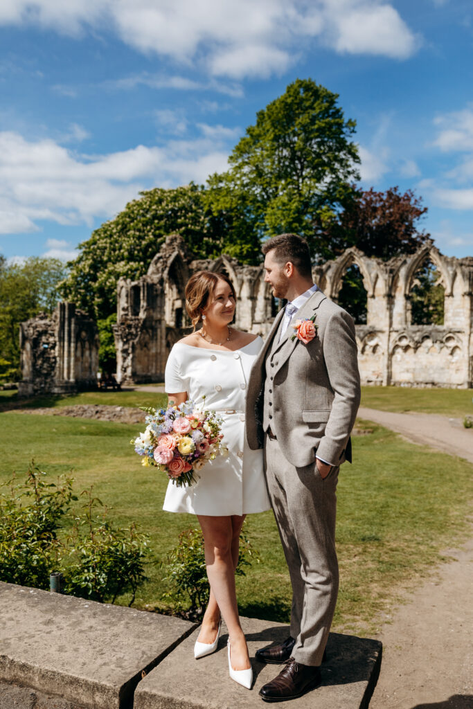 Bride and Groom in sunshine in York Museum Gardens in front of ruins