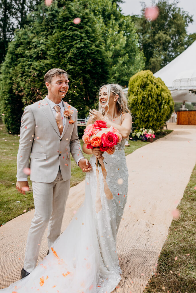 Bride and groom smiling in confetti