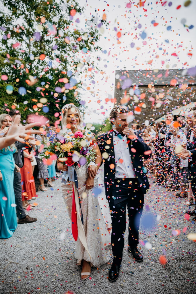 Bride and Groom walk through confetti at The Outbarn Clitheroe