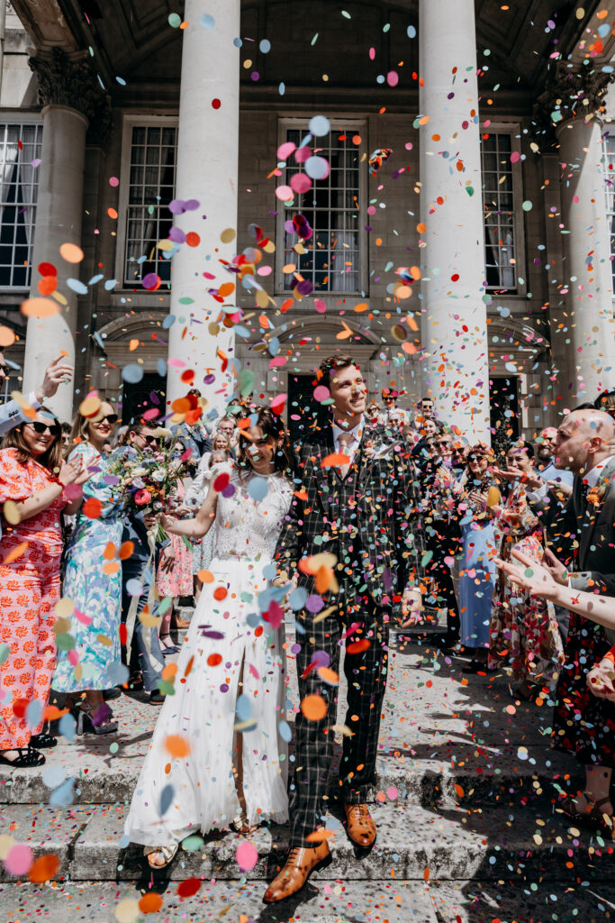 Bride and Groom in colourful confetti at Leeds Civic Hall
