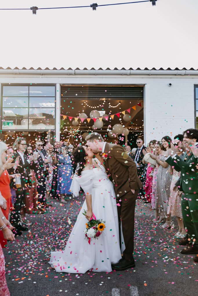 Bride and Groom kiss in colourful confetti at Project House Leeds