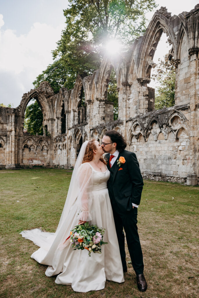 Bride and Groom kissing in front of York Ruins