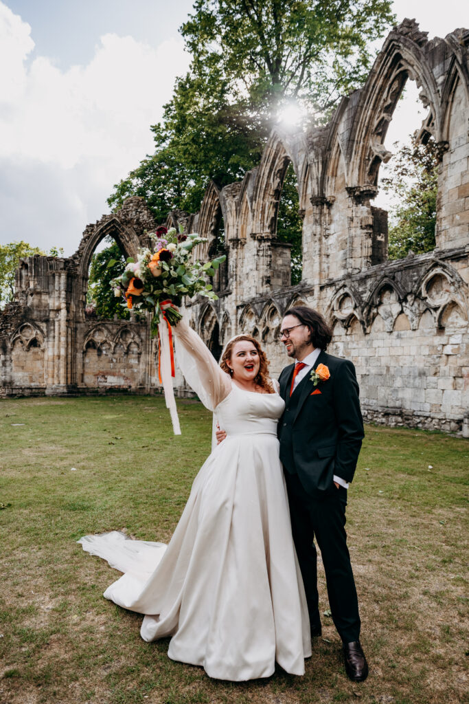 Bride and groom wooping in York museum Gardens