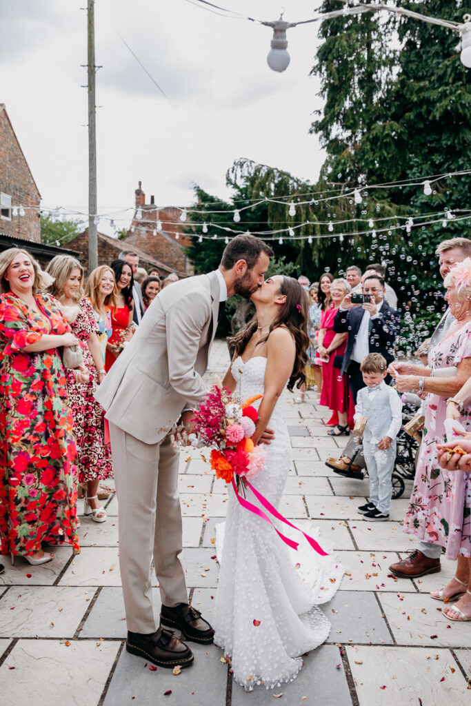 Bride and Groom kiss through confetti at White Syke Fields