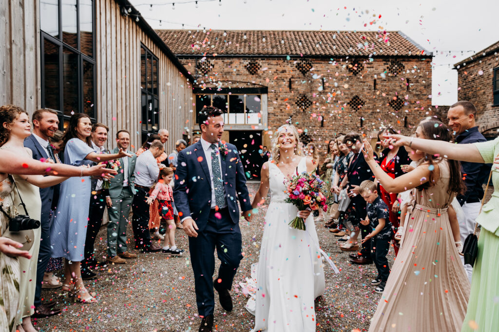 Bride and Groom in colourful confetti at Lodge Farm Weddings York