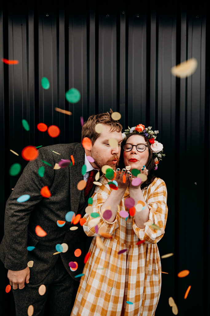 Bride and Groom blowing confetti at The Giraffe Shed