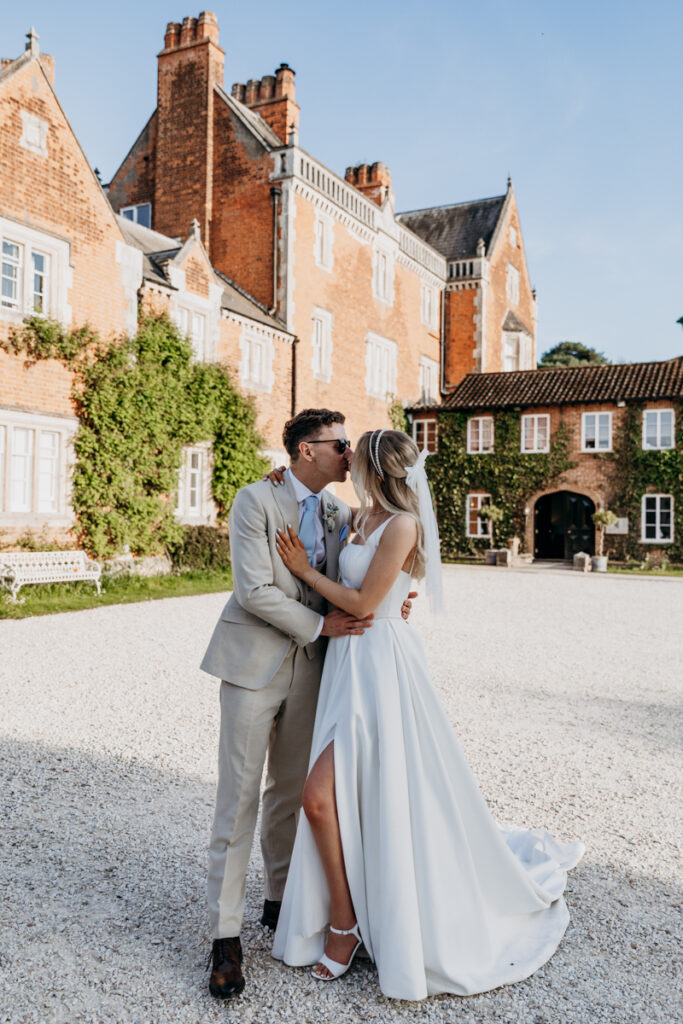 Bride and groom kissing outside Thicket Priory York