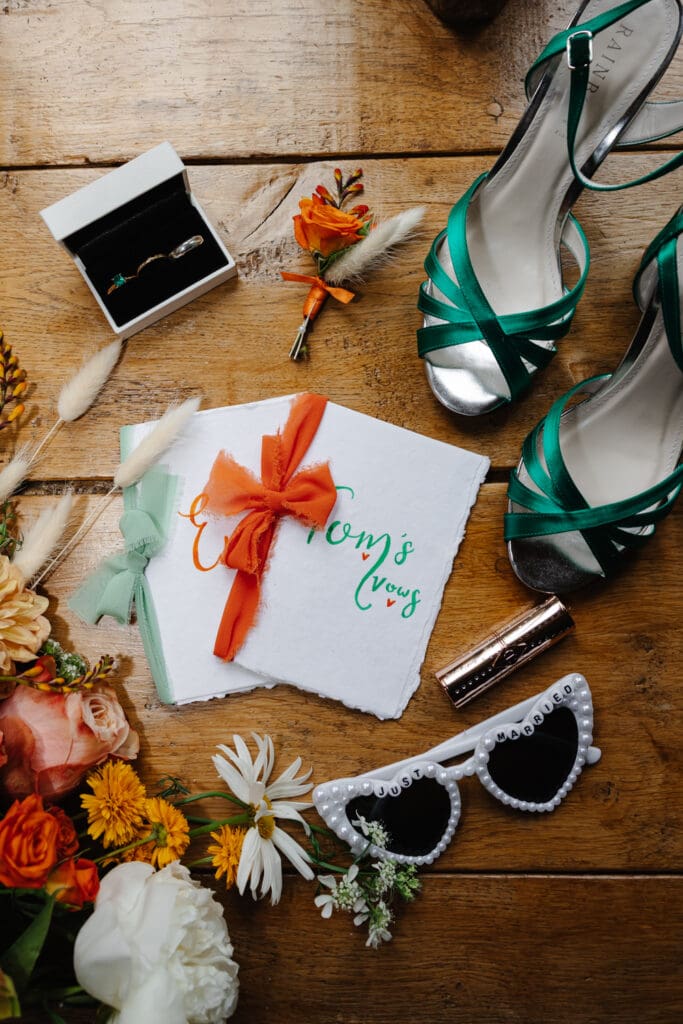 Flatlay of wedding vows and shoes and sunglasses