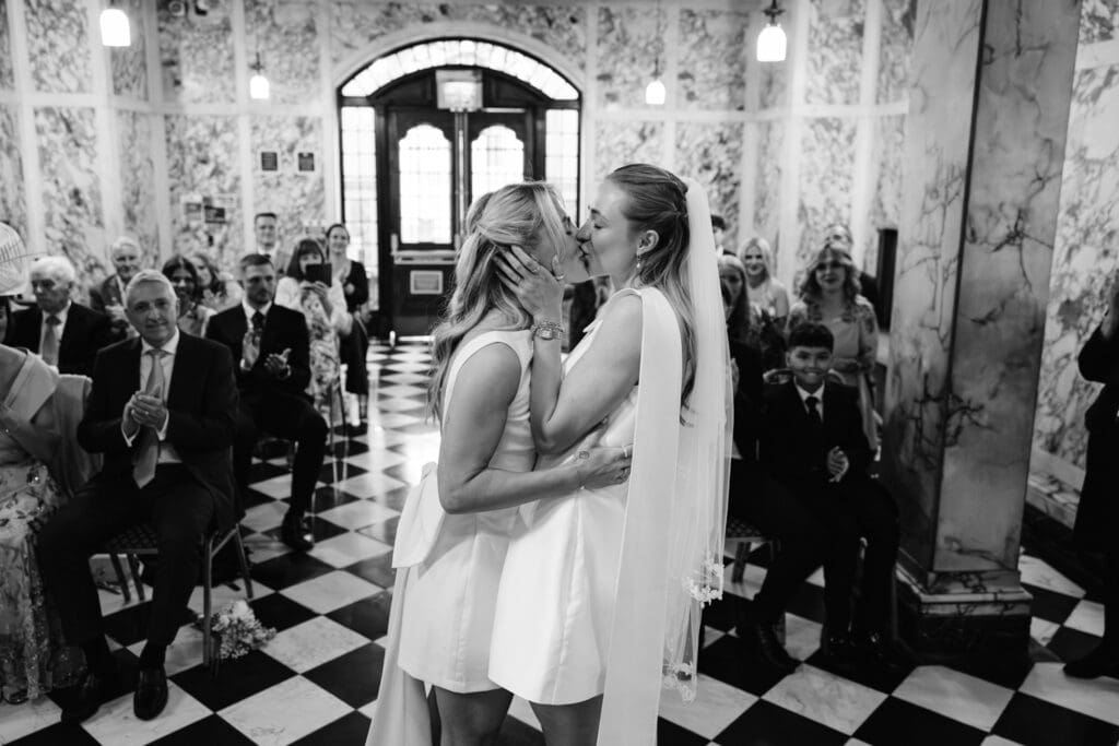 Two brides kissing at Stockport Town Hall